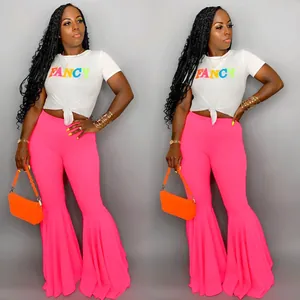 Detalle de la camiseta blanca con nudo 'FANCY' y pantalones acampanados rosas con volantes