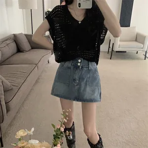 Detalle de blusa de punto calada negra con cuello en V, diseño estilo perezoso y bordes desgastados