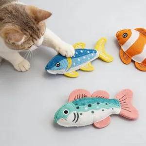 Nahaufnahme von realistischen Plüschfisch-Katzenminze-Spielzeugen mit einer spielenden Katze