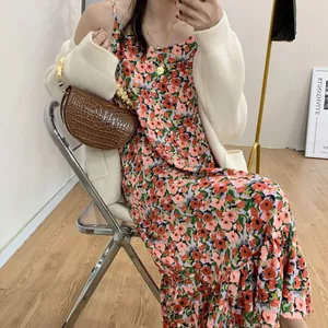 Elegant cream oversized knit cardigan paired with a floral dress and brown croc bag