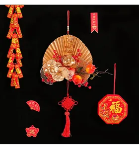Detail of festive gold fan floral arrangement with red berries and Chinese knot ornament