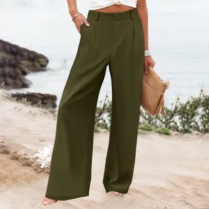 Eleganti pantaloni larghi a vita alta verde oliva da donna in un ambiente da spiaggia.