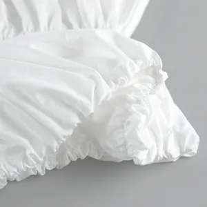 Macro view showing the ruched elasticated hem detail on a white summer bandeau top garment