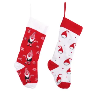 Pair of knitted red and white Christmas stockings with festive gnome and hat patterns