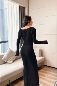 Rear view of a sexy black long-sleeved backless beach cover-up dress on a model