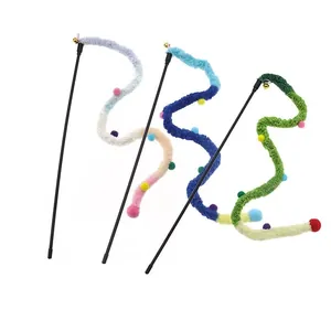 Dettaglio di tre bacchette gioco per gatti in peluche con campanellini e pompon colorati
