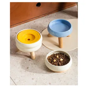 Set van minimalistische keramische voerbakken met houten poten in blauw geel beige