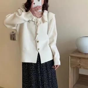Elegant white ruffle collar knit cardigan with bow tie paired with a polka dot skirt