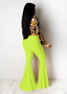 Back view showing the fit of the baroque patterned crop top and neon ruffled flare pants