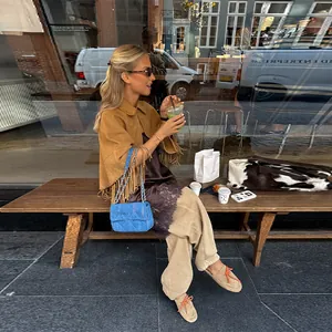 Vista lifestyle del poncho autunnale da donna con frange e revers color cammello