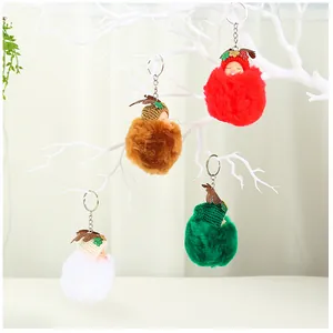Cuatro ángeles de peluche de colores colgados de una rama decorativa blanca