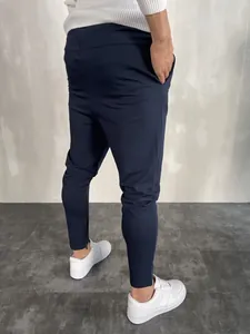 Vista posteriore dettagliata di pantaloni sportivi blu scuro con polsini funzionali a cerniera