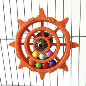 Detail view of a parrot toy ship wheel with colorful beads mounted on a wire birdcage.