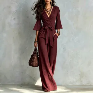 Elegant burgundy deep V-neck wide-leg jumpsuit with bell sleeves and waist tie
