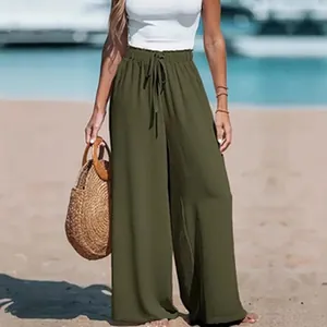 Detailansicht einer olivgrünen Hose mit weitem Bein für Damen an einem Sandstrand
