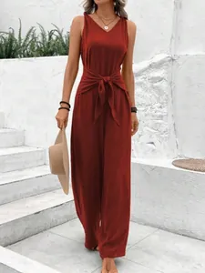 Chic rust red sleeveless V-neck wide-leg jumpsuit featuring a stylish waist tie-knot design