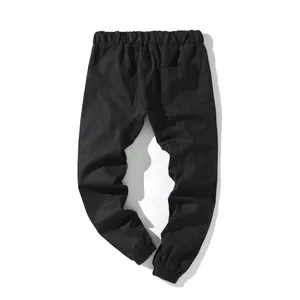 Vista posterior detallada de pantalones cargo negros holgados para hombre con cintura elástica