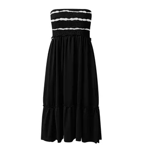 Detail of black strapless smocked midi dress with white stripes and ruffled hem