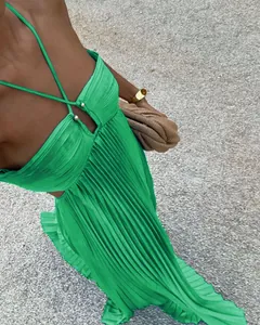 Detailed view of the vibrant green pleated fabric and halter neckline of the maxi dress