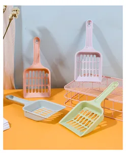 Detail view of four colorful macaron plastic cat litter scoops with hollow mesh design