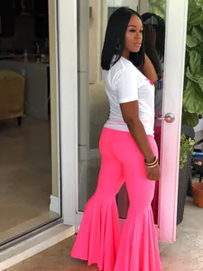 Detalle de pantalones acampanados rosas de talle alto con volantes dramáticos sexy.