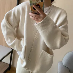 Close-up of soft white oversized knit cardigan with front pockets and deep V-neckline