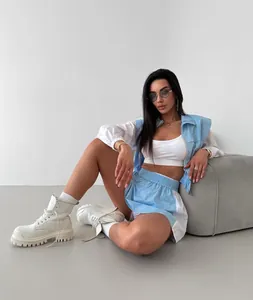 Woman wearing a trendy blue and white color block sporty set with jacket and shorts.