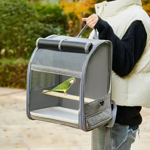 Detailweergave van een ademende vogelrugzak met een papegaai op een houten stokje.