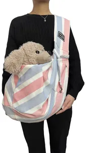 Model wearing a pink and blue striped pet sling bag carrier with a plush toy dog inside