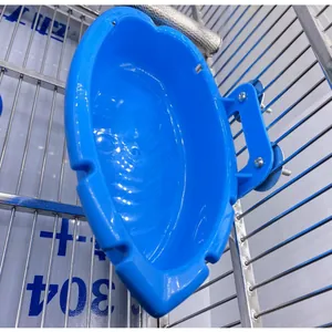 Nahaufnahme einer blauen Vogelbadewanne aus Kunststoff, montiert an einem Metallkäfig.
