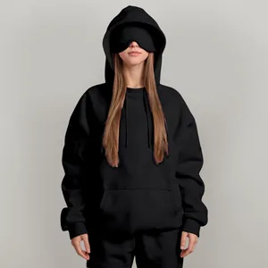 Close-up detail of black oversized hoodie featuring a unique functional built-in eye mask