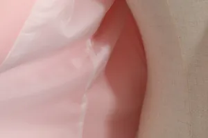 Detail of smooth pink satin lining and stitching on a slim fit women's blazer jacket