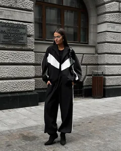 Fashionable street style view of women's black and white color-block tracksuit set outdoors.