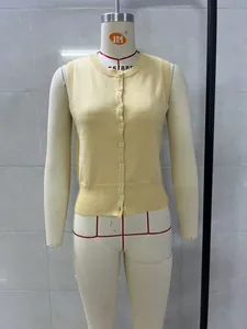 Detail view of a yellow knitted sleeveless button-up vest on a mannequin display.