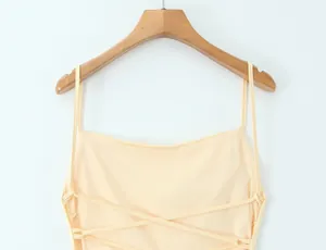 Close-up detail of light yellow backless dress with elegant criss-cross straps