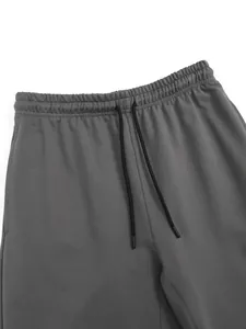 Vue détaillée de la taille élastique et du cordon de serrage noir sur ce jogging gris