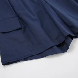Close-up detail of navy blue cotton linen shorts showing fabric texture and pocket