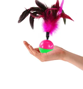 Detail showing colorful feather teaser on a pink and green tumbler cat toy