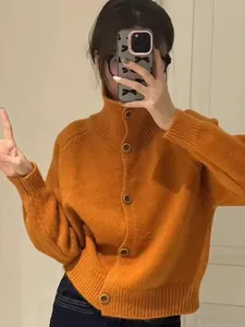 Detalle de una mujer con un cárdigan de punto naranja y cuello alto en un selfie