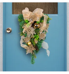 Detail of Christmas teardrop swag with gold flowers and pine needles for door decor.