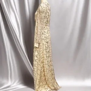 Side view of an elegant sequined mesh evening gown showing intricate fabric details