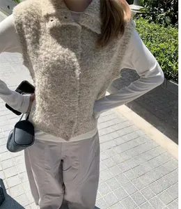 Vue détaillée d'un gilet élégant en laine bouclée beige pour femme en extérieur