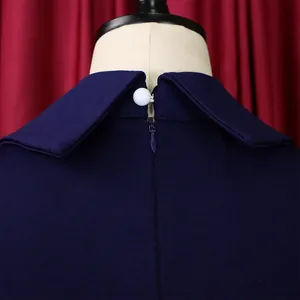 Close-up detail of the navy blue dress back collar featuring a pearl button and hidden zipper