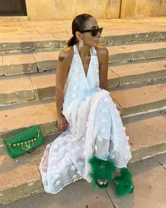 Gros plan élégant d'une robe longue blanche à licou et col en V avec appliques florales en 3D