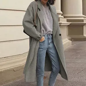 Detail shot of the grey long woolen overcoat on model showing relaxed fit and length