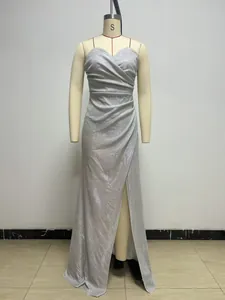 Elegant silver sparkling ruched evening dress with high slit shown on mannequin