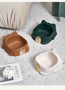 Three colors of lucky cat-shaped pet bowls displayed in a modern home interior setting