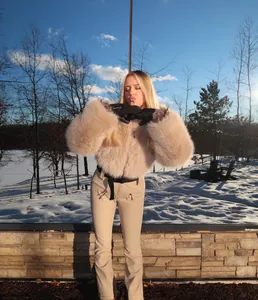 Outdoor winter shot of woman in khaki fluffy jacket and slim-fit ski pants