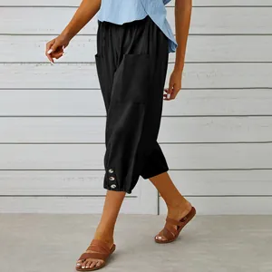 Detailed view of women's black linen capri pants with drawstring and button hem
