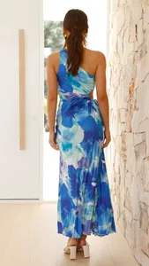 Back view of a one-shoulder blue floral maxi dress with pleated fabric and waist cutout.